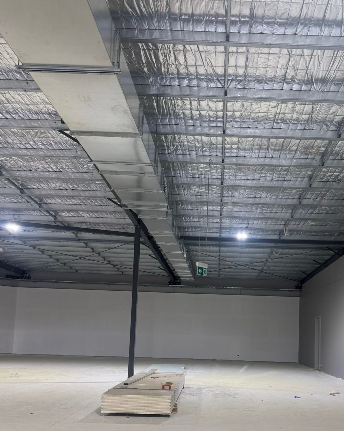 Cable tray and high-bay lights across the ceiling of a new commercial building